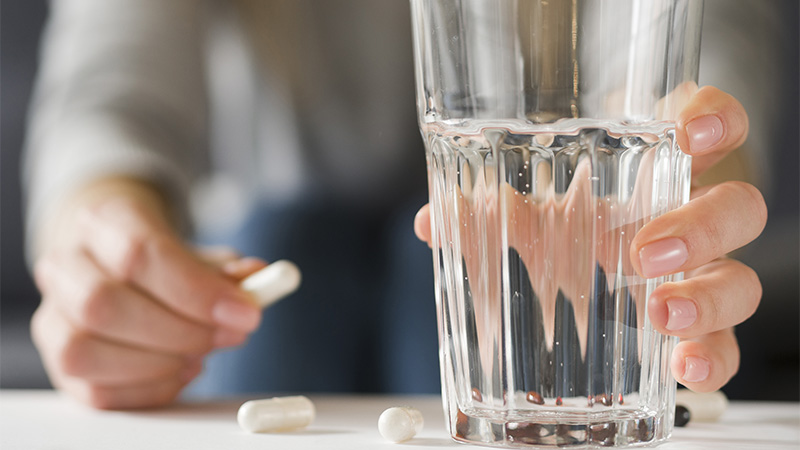 close up woman holding pill