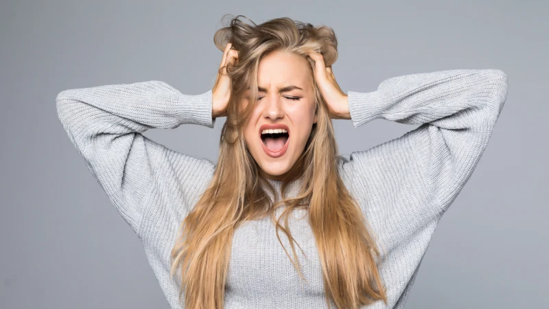 Zašto je magnezijum ključan za žene sa sindromom policističnih jajnika (PCOS)? 3 portrait frustrated angry woman screaming out loud pulling her hair out isolated gray background