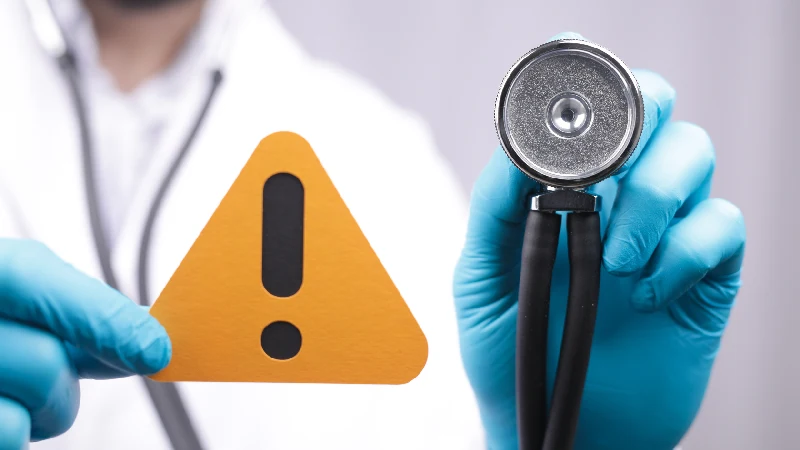 Kurkuma – prijatelj ili neprijatelj jetre? 4 Doktor sa rukavicama drži znak upozorenja