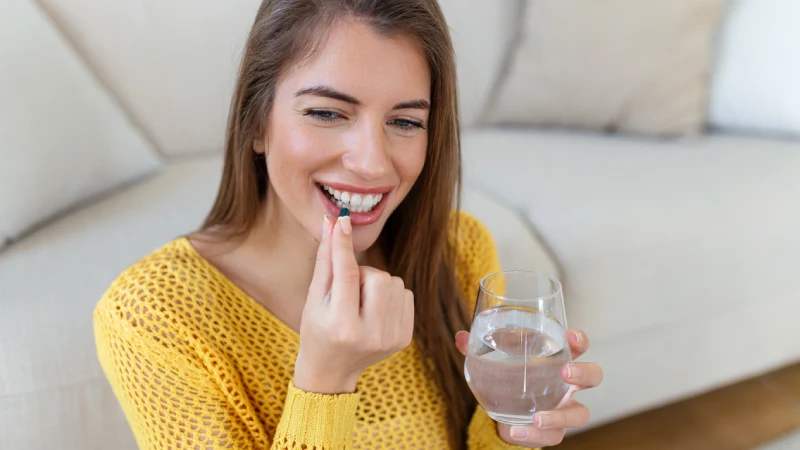 Žena uzima kapsulu magnezijuma kao deo dnevne suplementacije