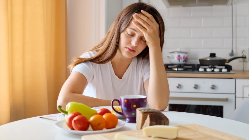 Stresna žena drži glavu i izgleda iscrpljeno