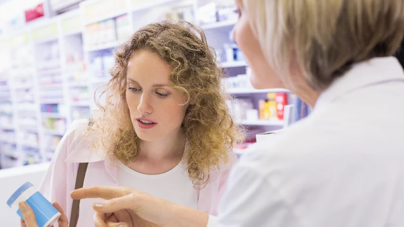 Farmaceut objašnjava kupcu informacije o suplementu u apoteci