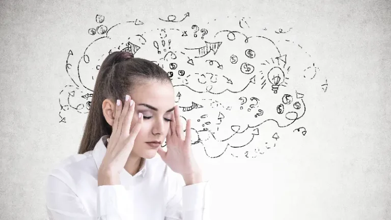 Žena drži ruke na slepoočnicama dok iza nje ilustracije predstavljaju haotične misli i mentalno opterećenje.