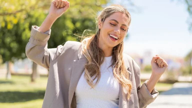Nasmejana žena na otvorenom odiše energijom i dobrim raspoloženjem, ilustrujući moringa i benefite moringa ekstrakta za vitalnost, energiju i opšte blagostanje organizma.
